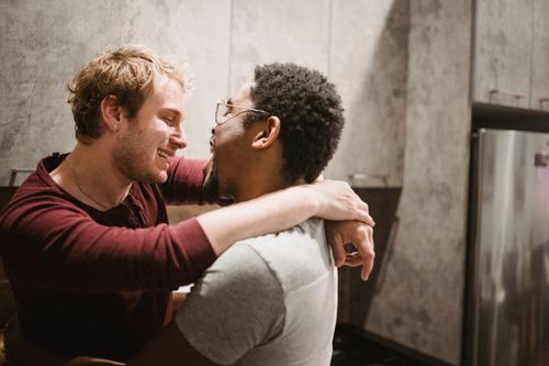 Free A loving interracial gay couple shares an affectionate moment in a modern kitchen setting. Stock Photo
