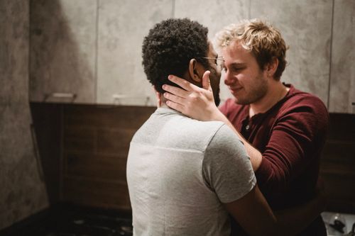 Free A heartwarming image of an affectionate couple embracing indoors, showcasing romance and togetherness. Stock Photo