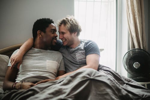 Two Men in Bed Looking at Each Other