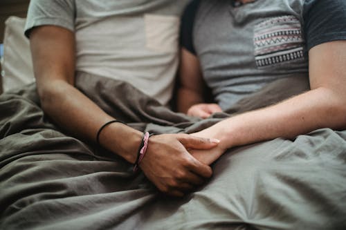 Free Two Men in Bed Holding Hands Stock Photo