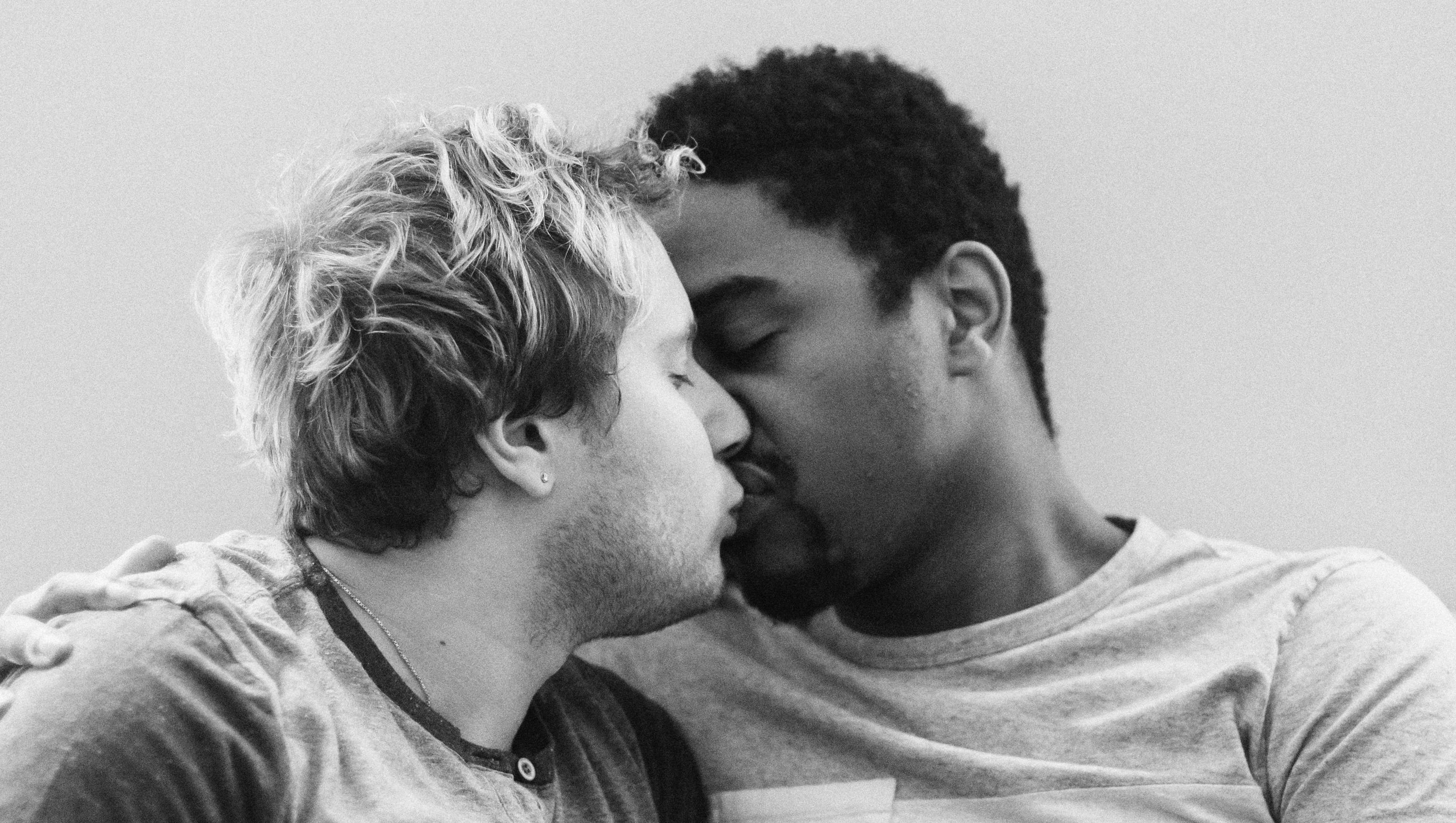 grayscale photography of two men kissing