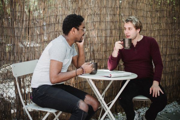 Two people chatting over coffee outdoors