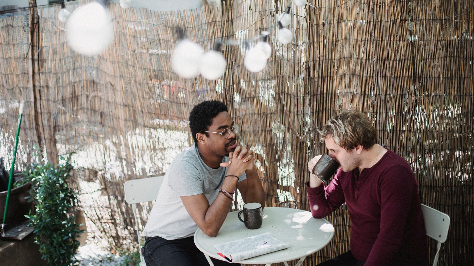 Two people sitting with coffee at an outdoor café table