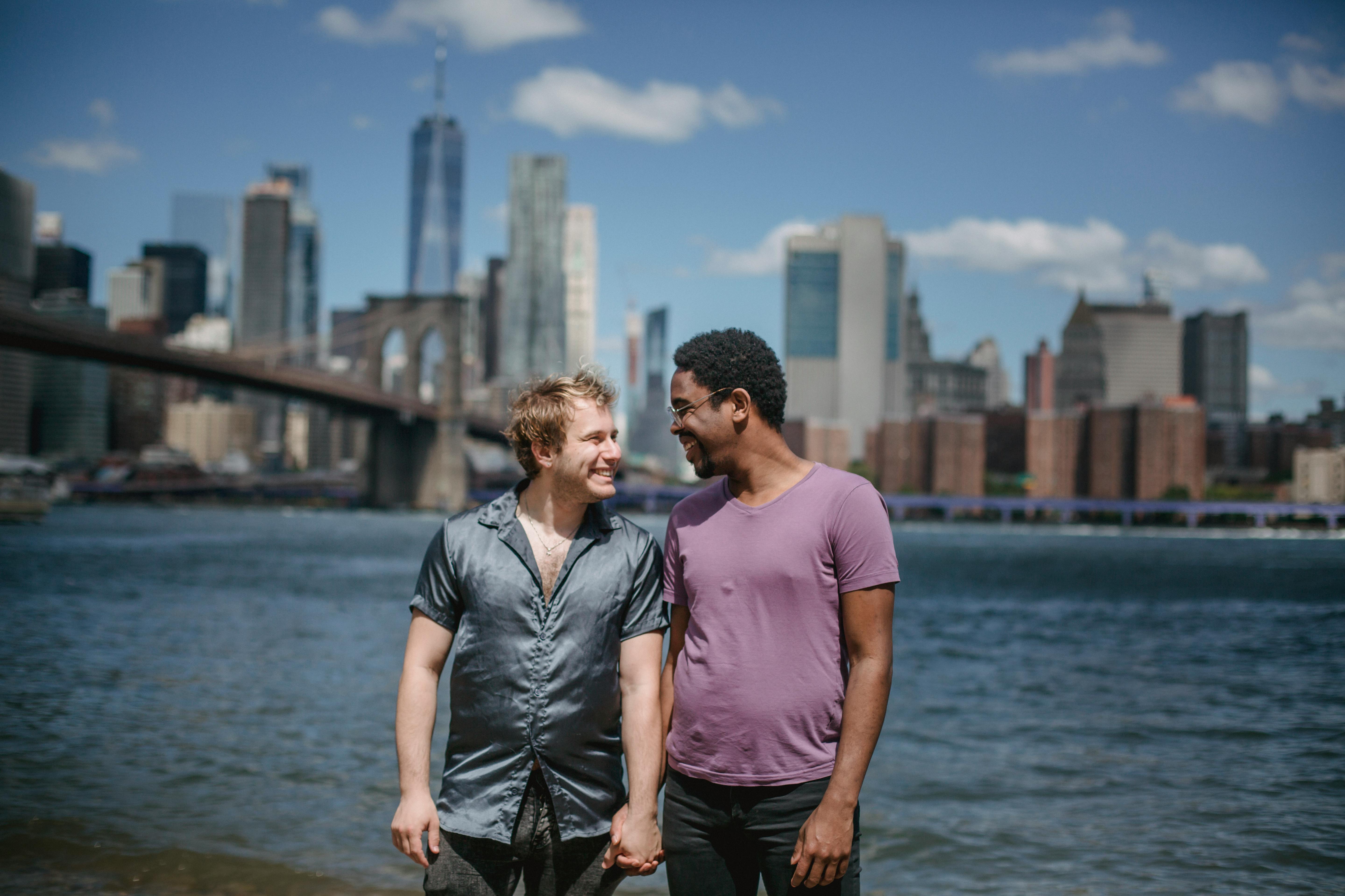 two men smiling and holding hands