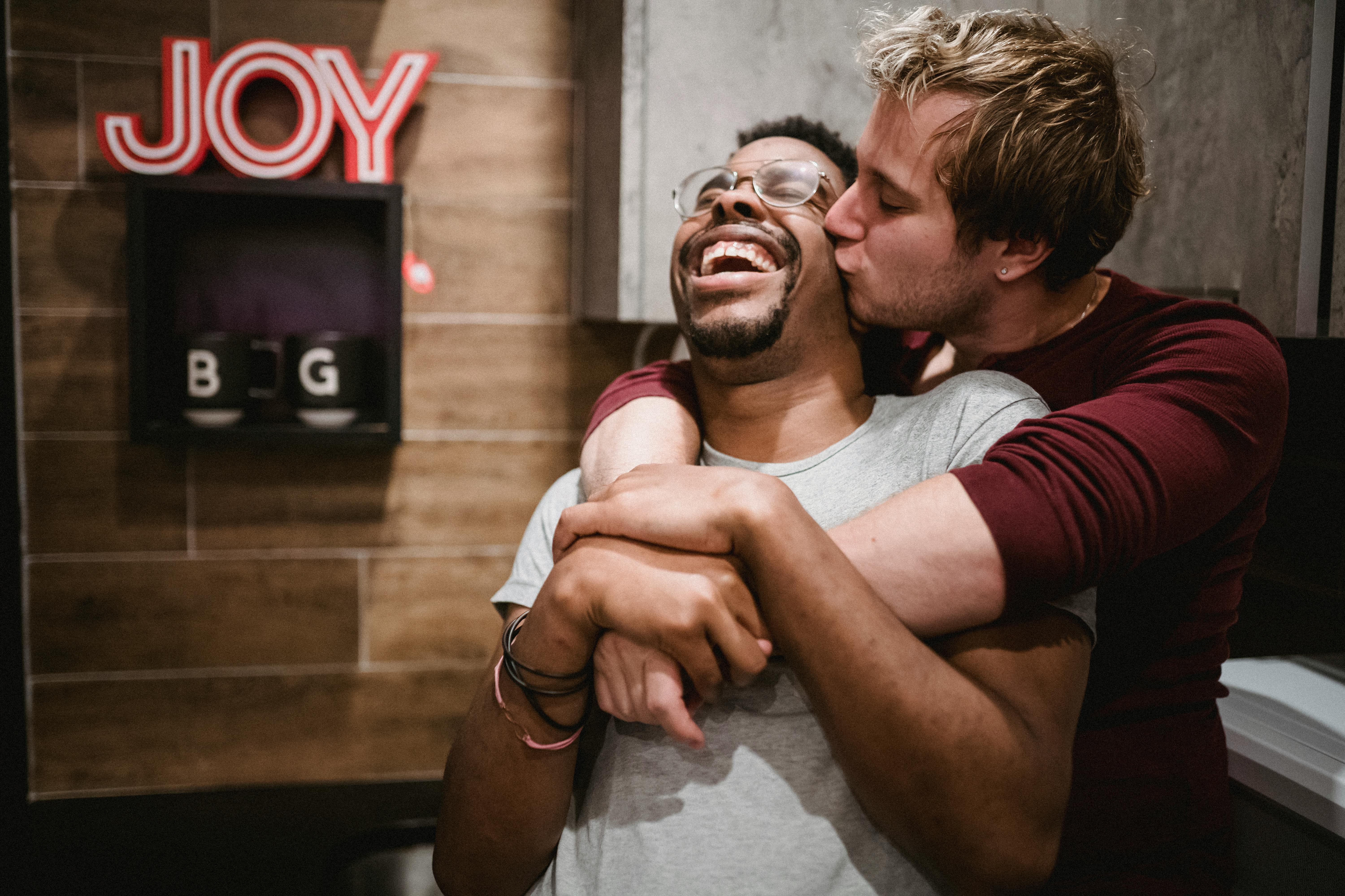 man hugging and kissing another man