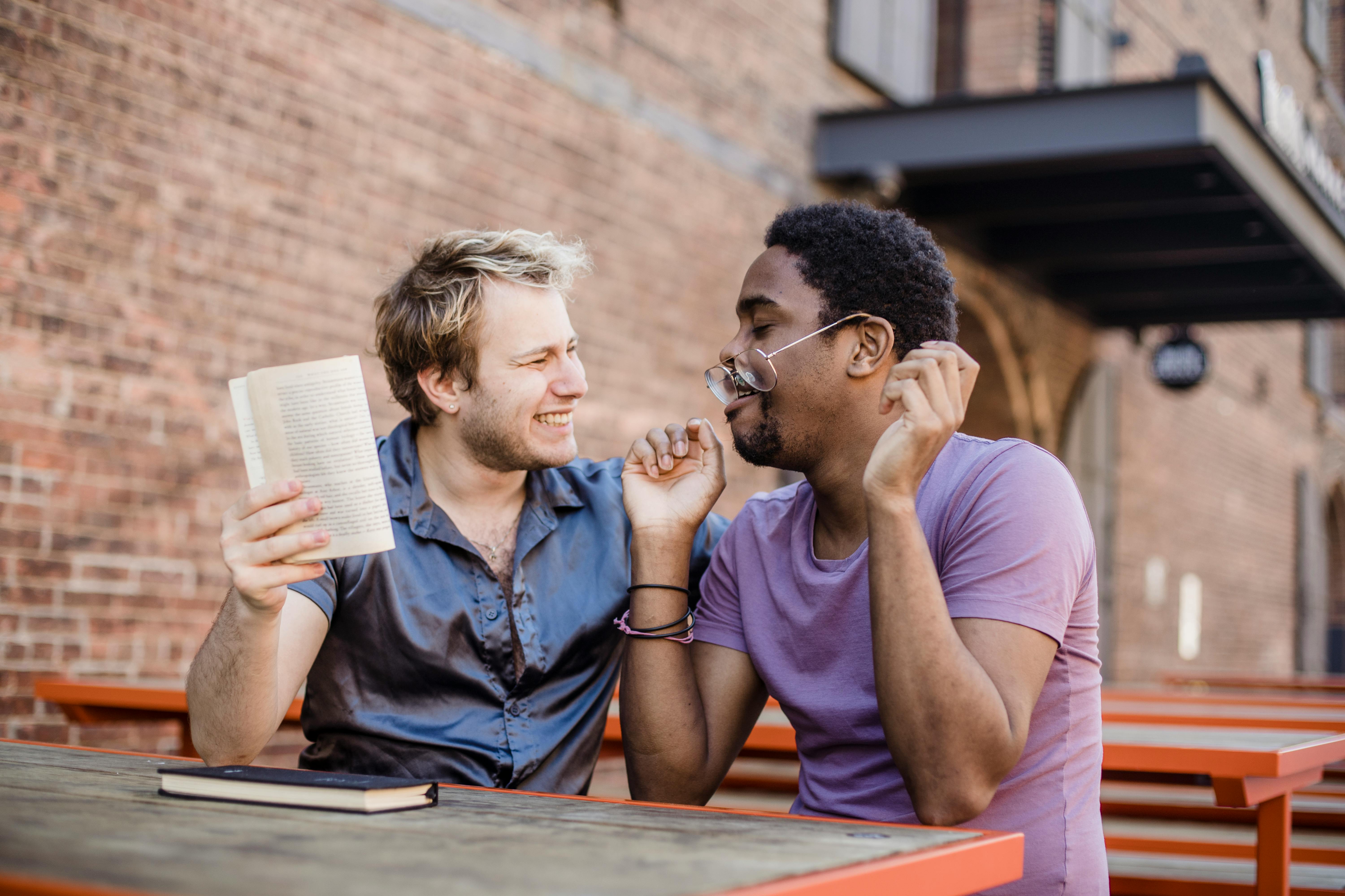 two smiling men sitting outside