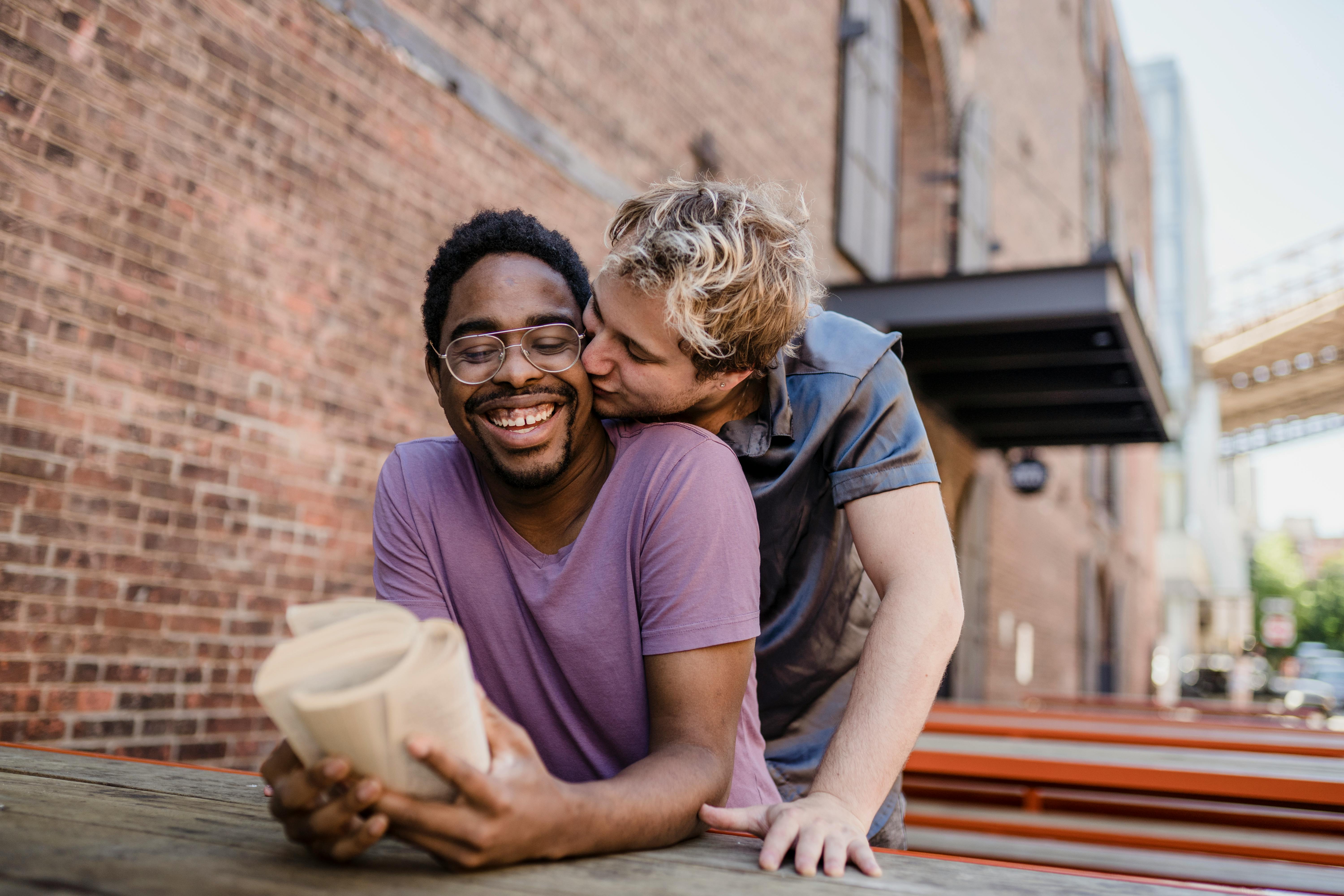 man kissing another man on the cheek