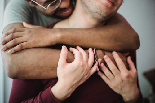 Free Man Hugging Another Man from Behind Stock Photo