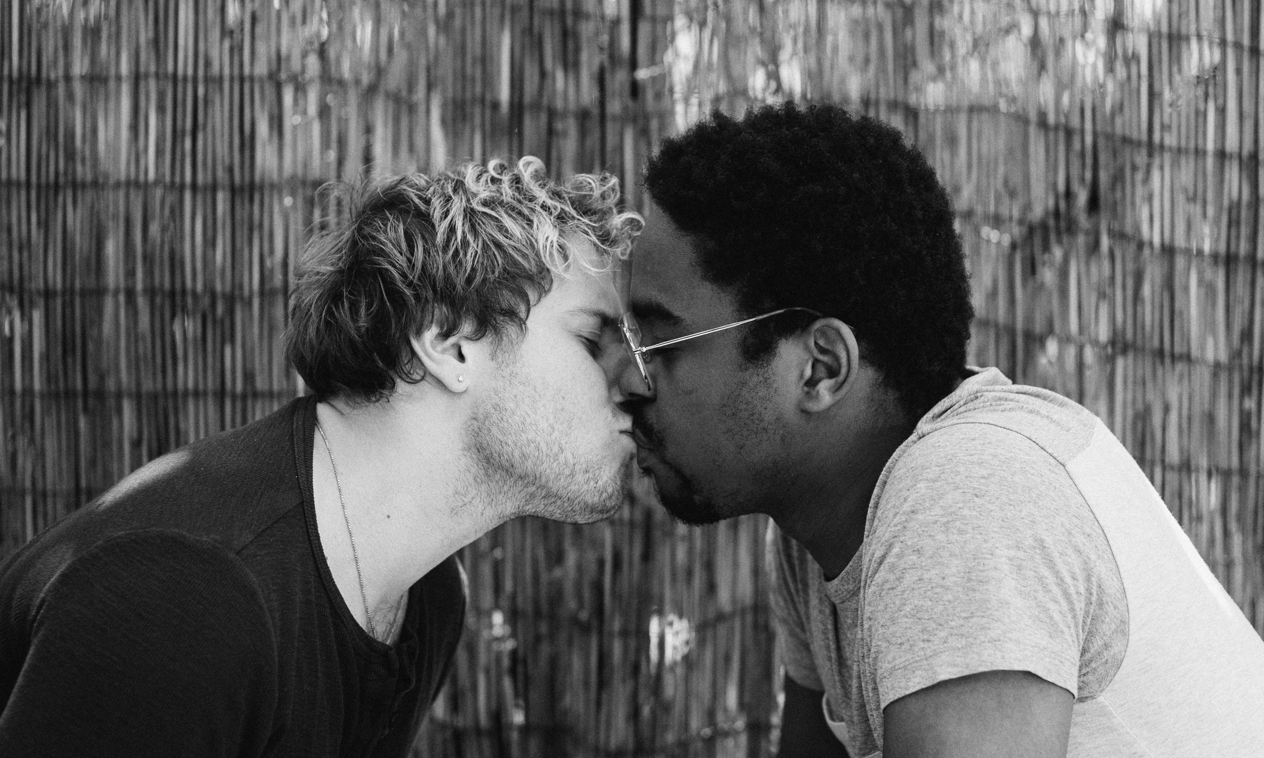 black and white photo of two men kissing