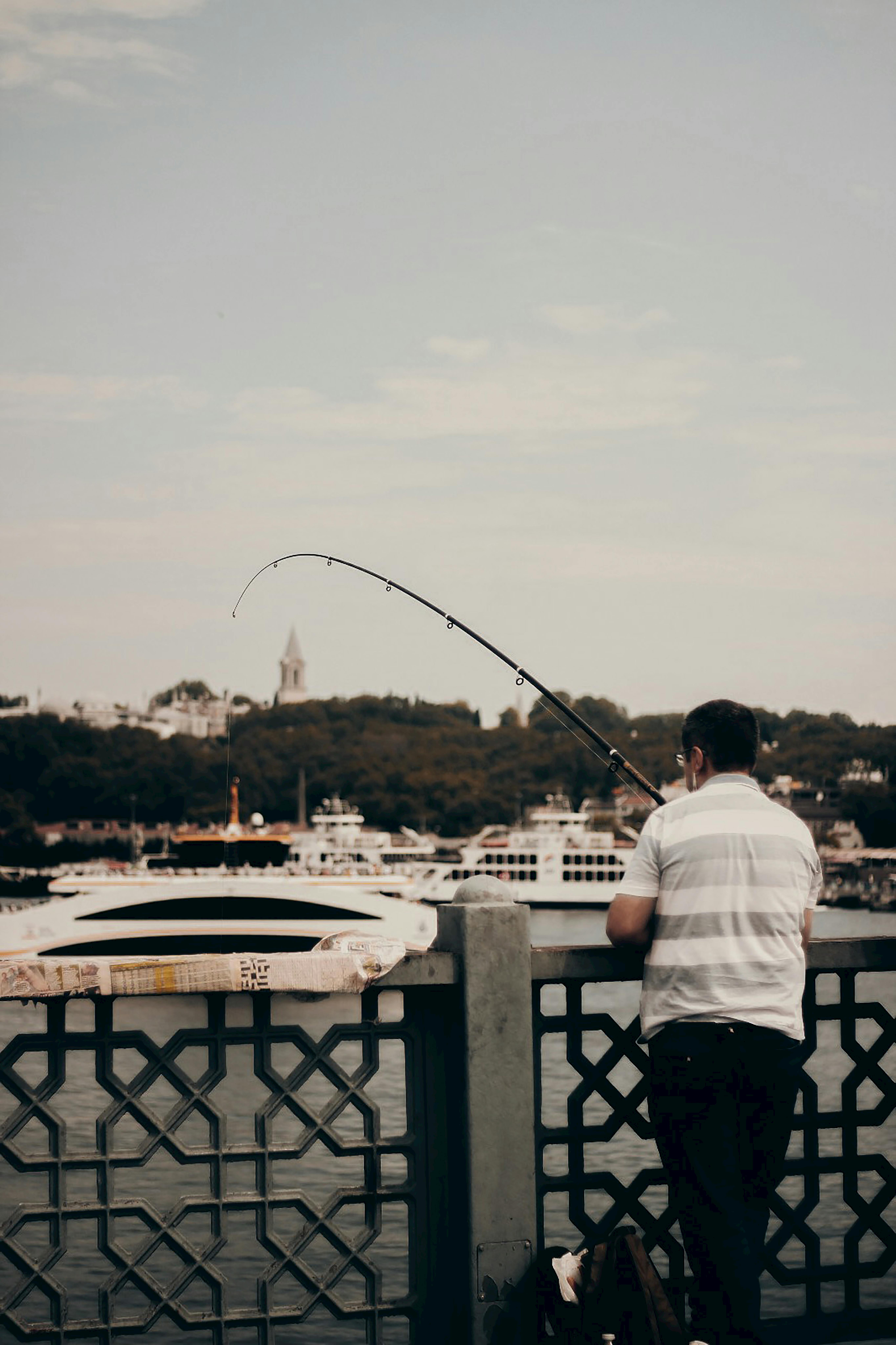 A Woman Sitting on Concrete Dock Fishing with a Couple · Free Stock Photo