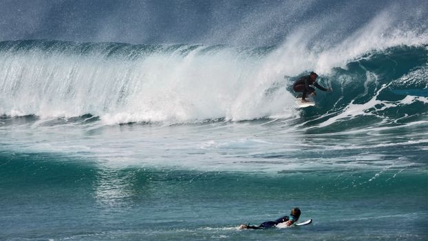 Surfers riding powerful waves, capturing the thrill and skill of ocean surfing.