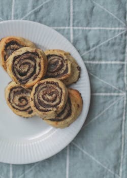 Delicious homemade cinnamon rolls on a white plate, perfect for breakfast.