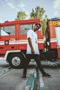 Man in White Shirt Standing Beside Red Truck