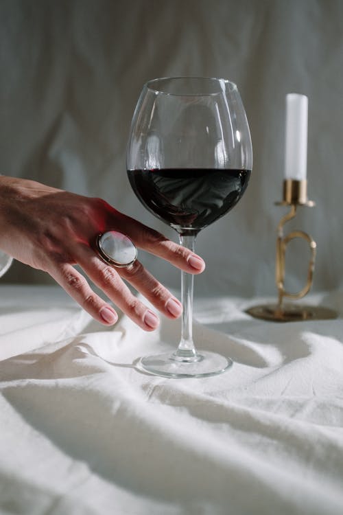 Person Holding Clear Wine Glass With Red Wine