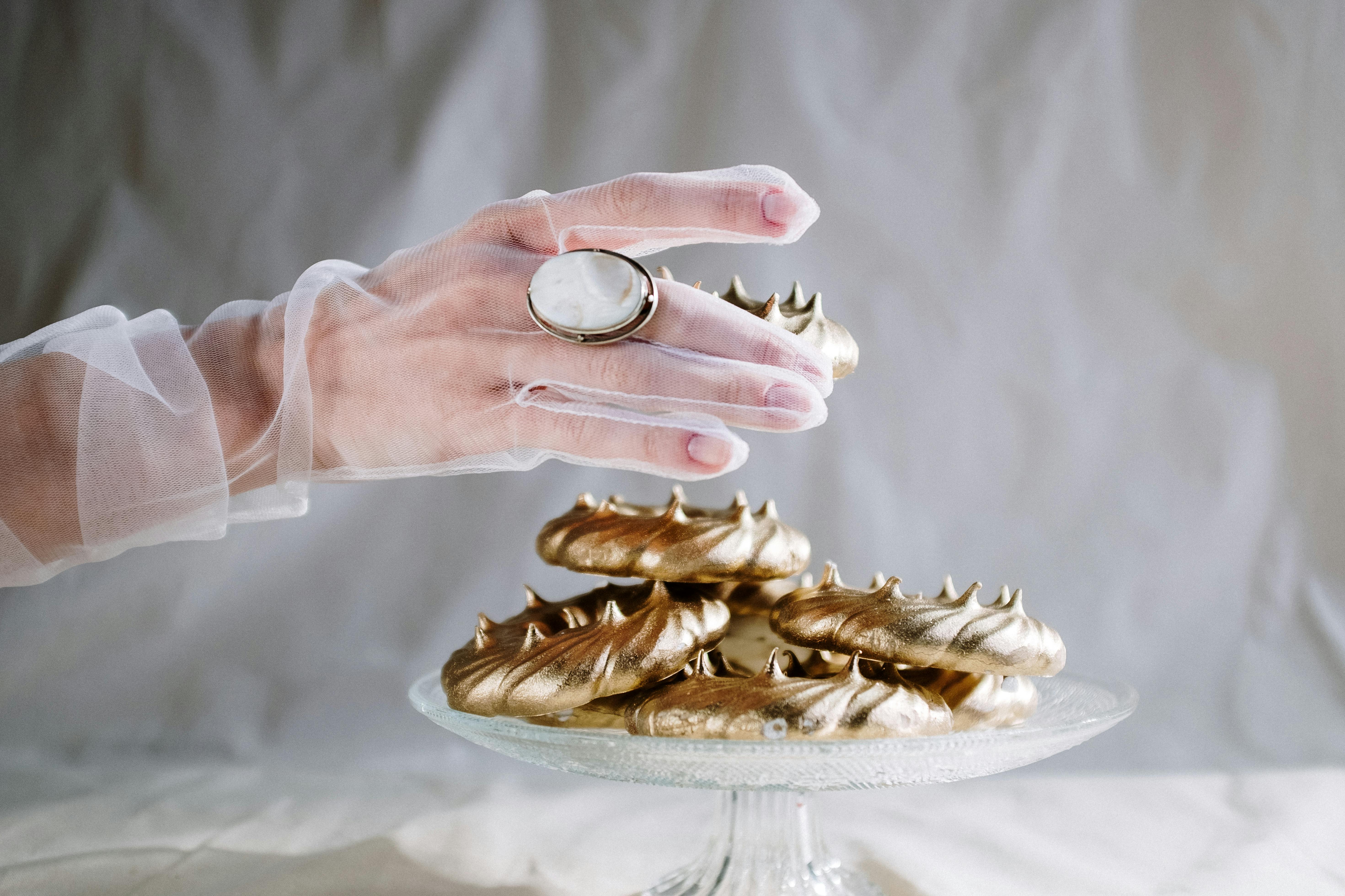 person holding brown wooden tray with gold ring