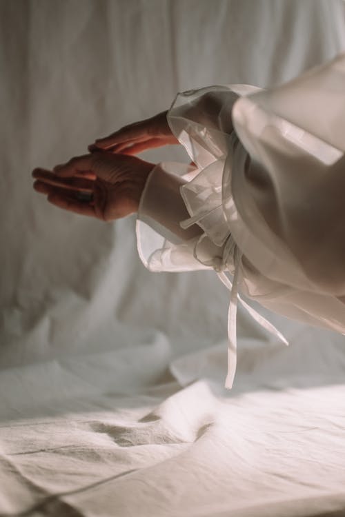 Person Holding White Textile on White Textile