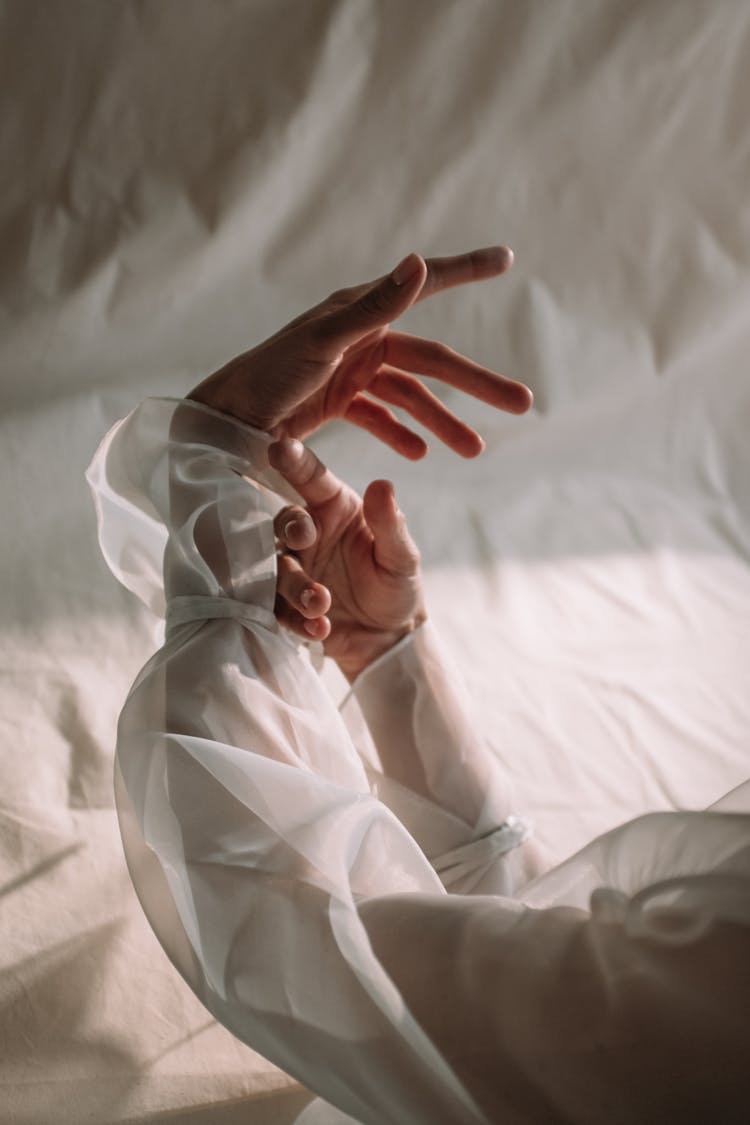 Persons Hand On White Textile