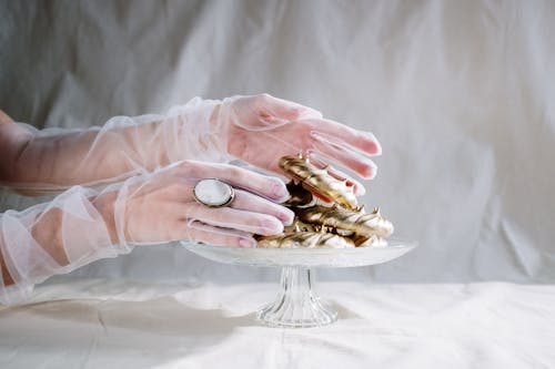 Person Holding Gold and Silver Round Coins