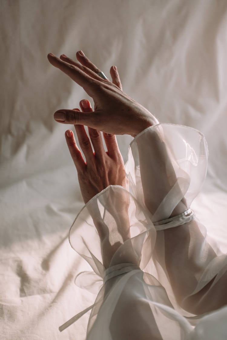 Persons Hand On White Textile