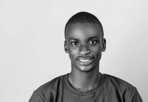Black and white portrait of a smiling African man on a white background.
