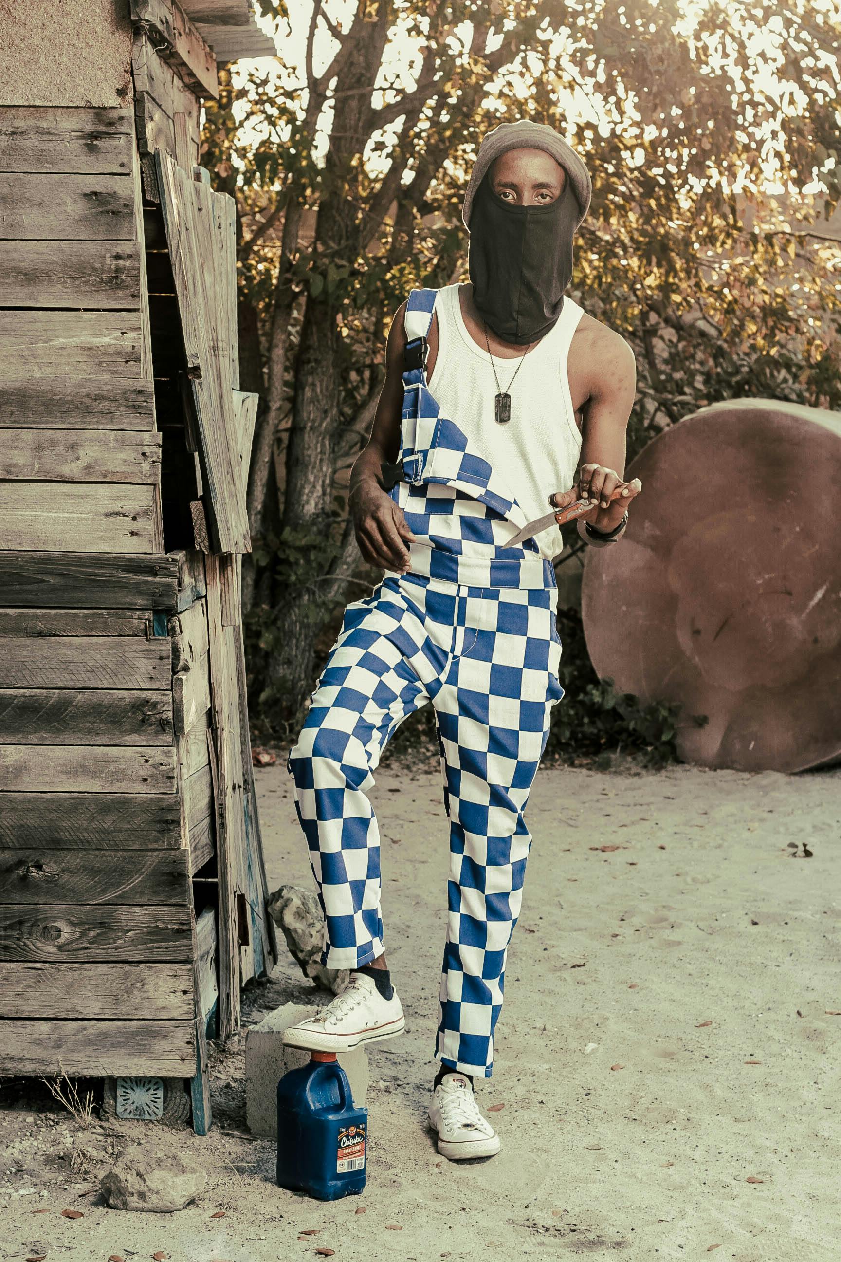 black man wearing cool overall with knife