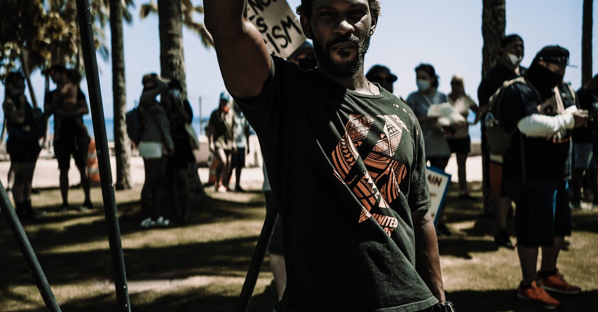 Photo by Daniel Torobekov A man raising his fist in protest at a Honolulu beach, advocating for equal rights.