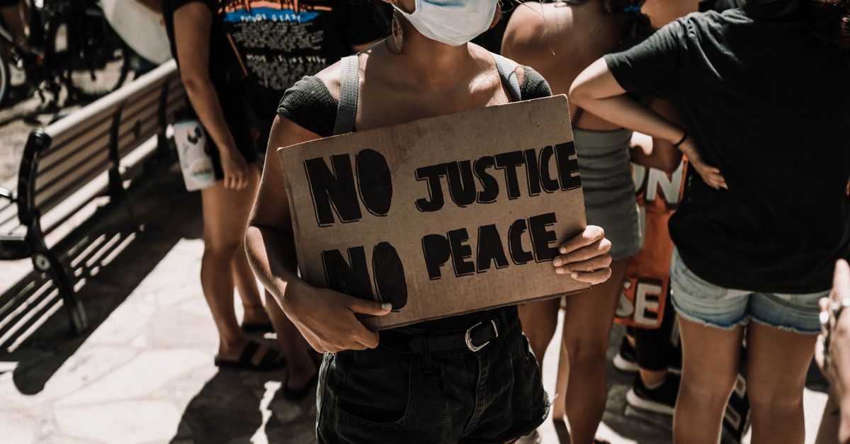 Photo by Daniel Torobekov A diverse group of protesters in Honolulu holding signs advocating for justice and equality.