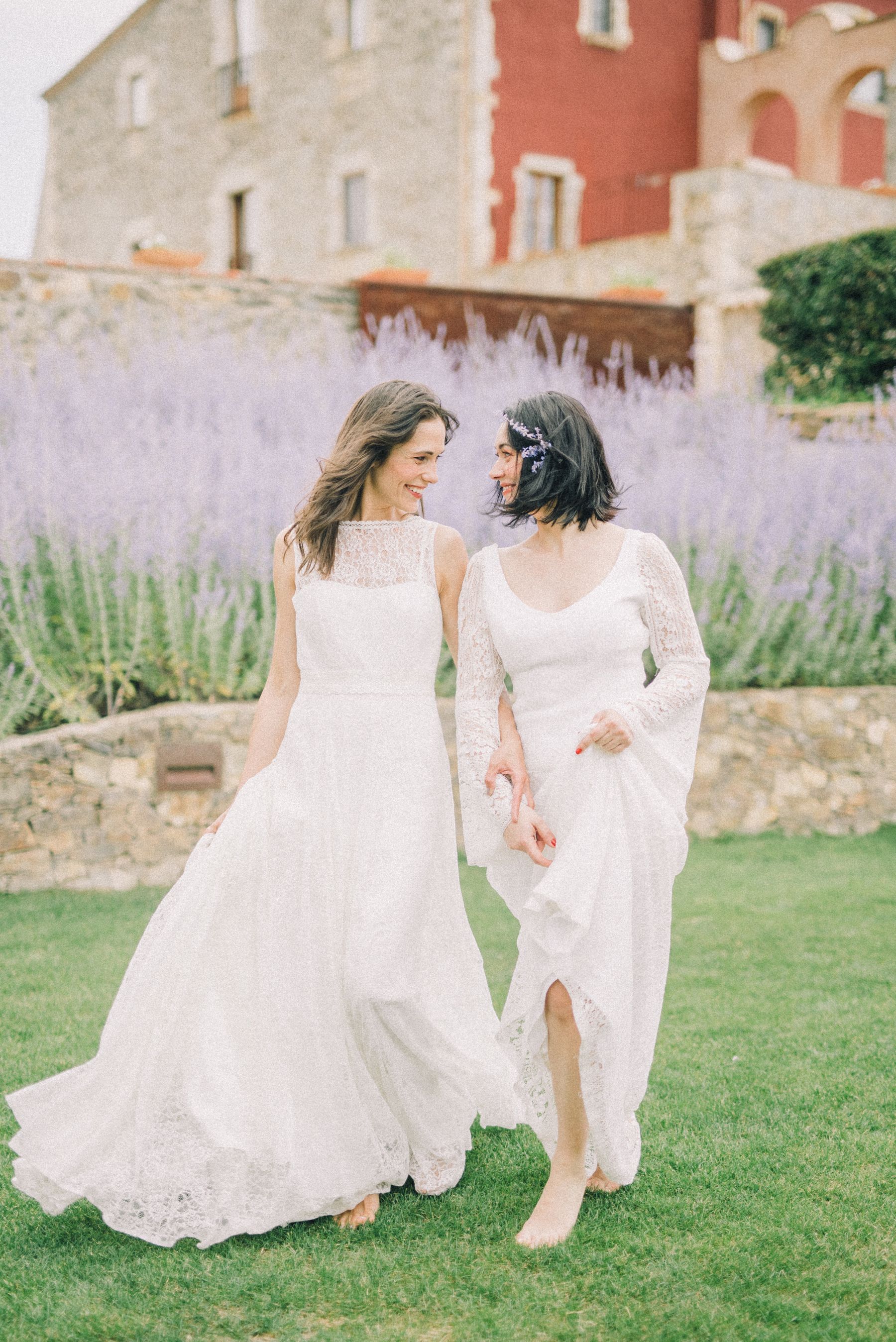 Las novias caminan juntas y sonríen en un jardín, imagen de muestra