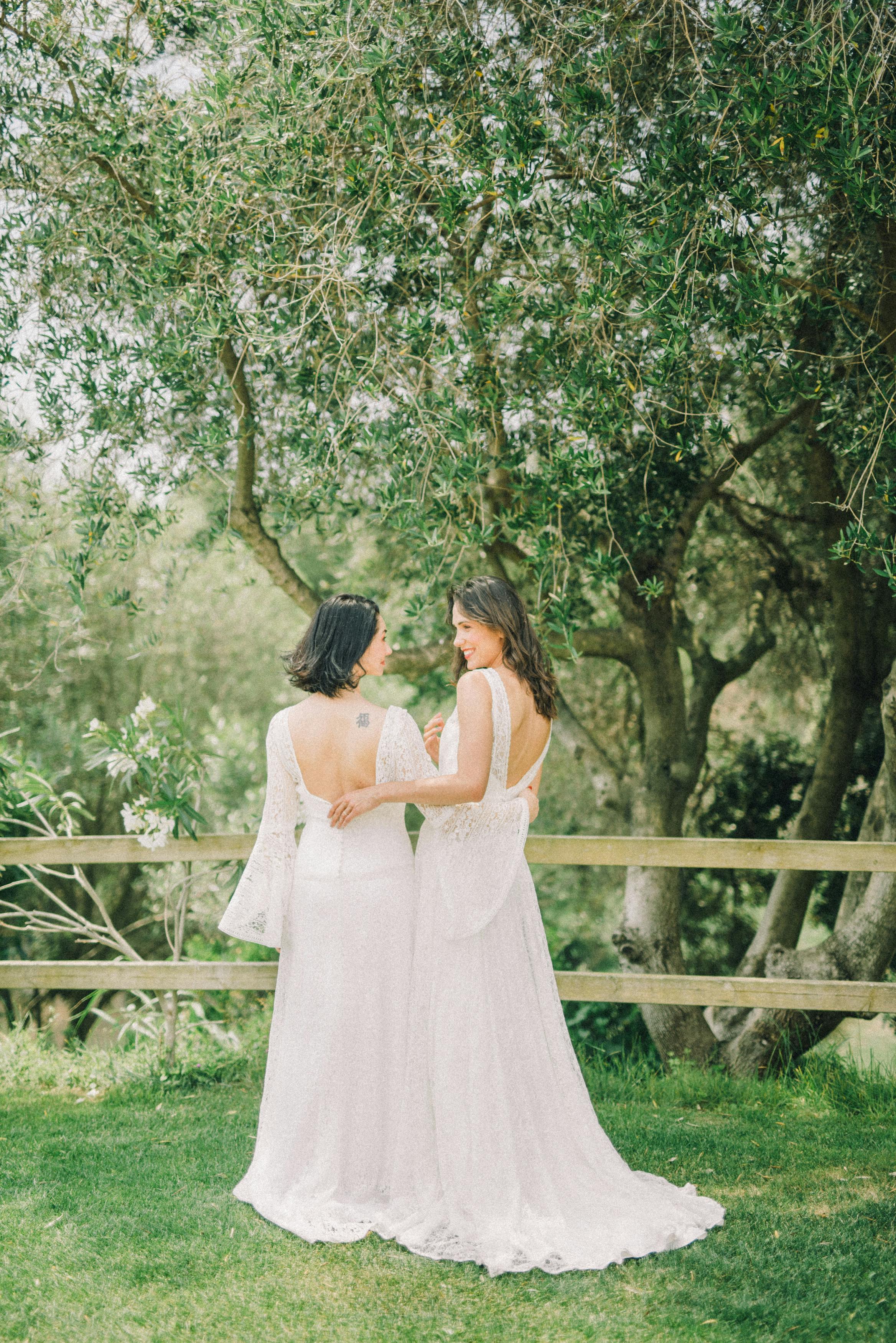 photo of women in white wedding dress looking at each other