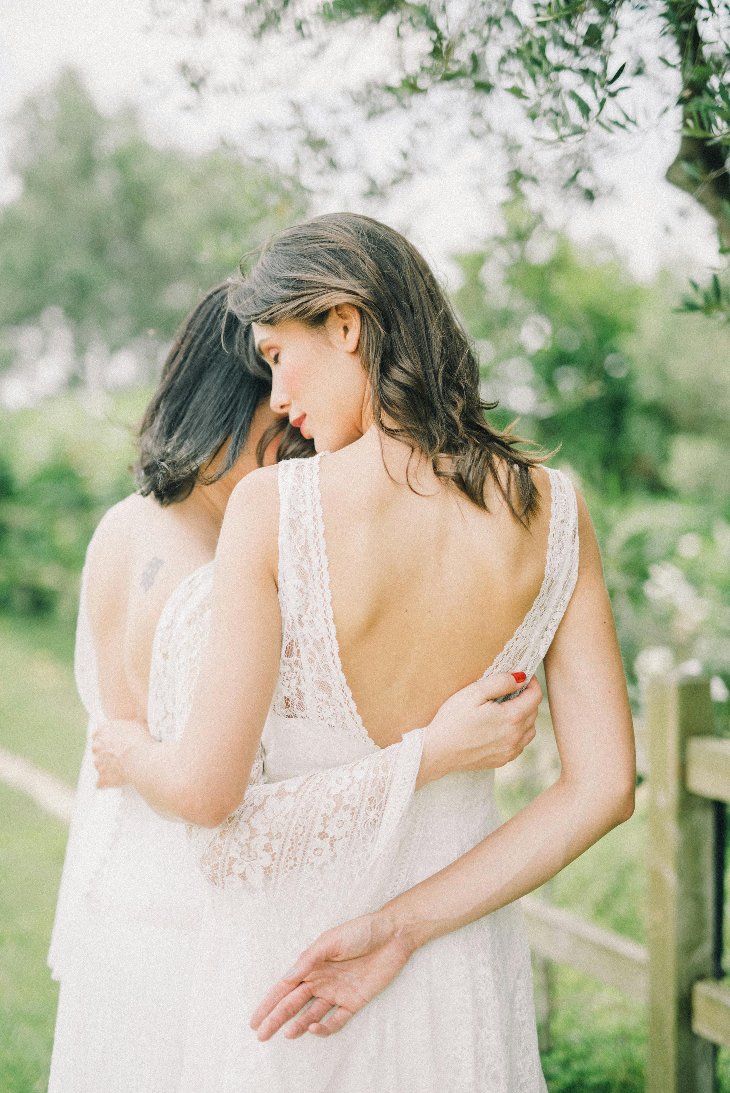 photo of women in white wedding dress hugging each other