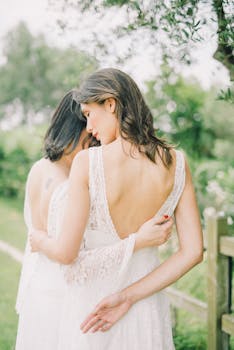 Romantic outdoor wedding photo of a loving LGBTQ+ couple embracing.