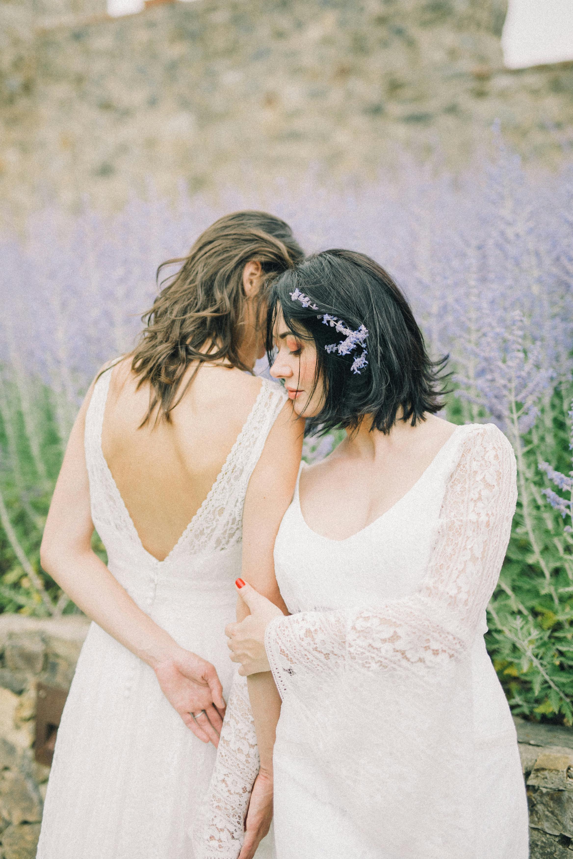 photo of women in white wedding dress standing next to each other