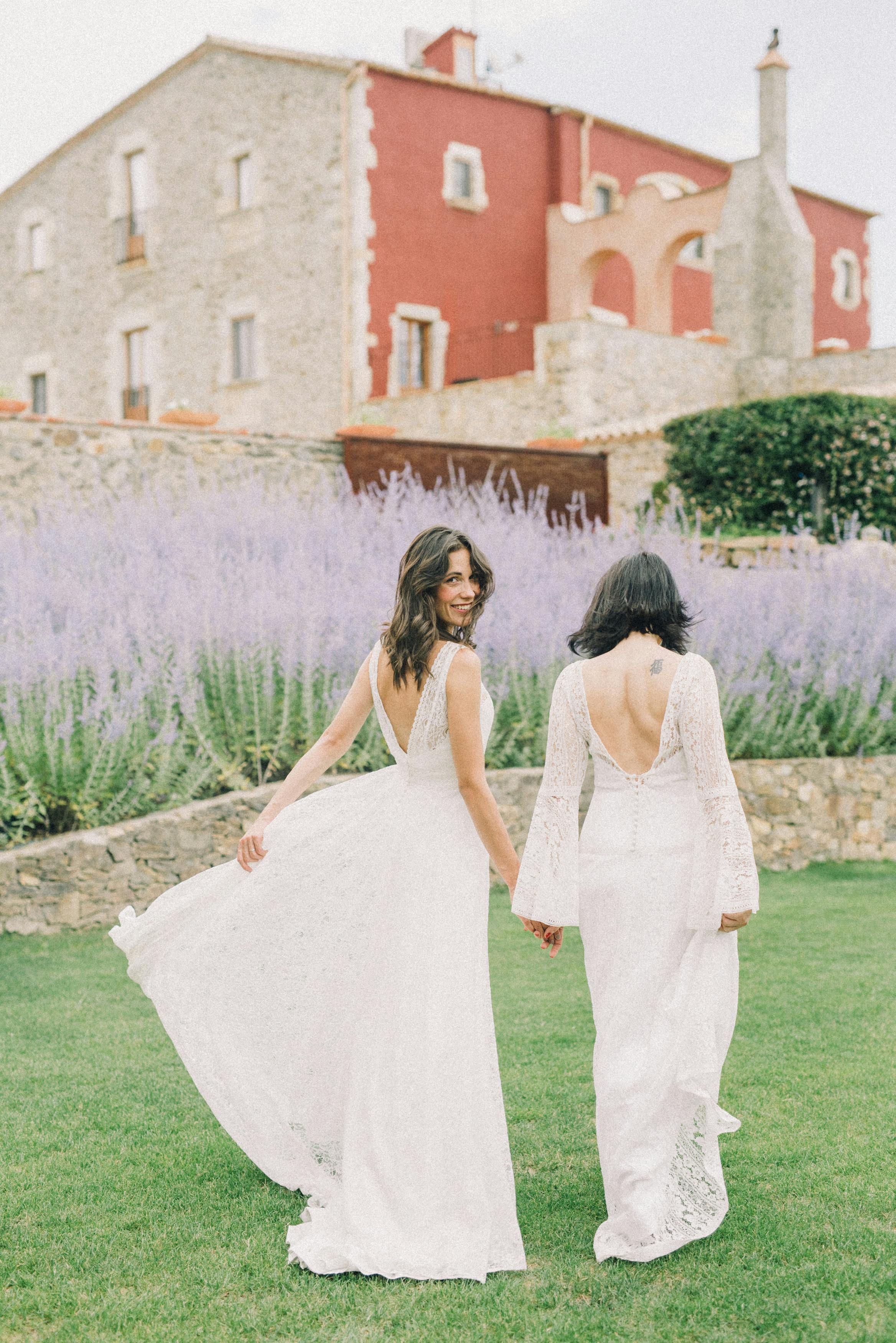 photo of women in white wedding dress walking on grass