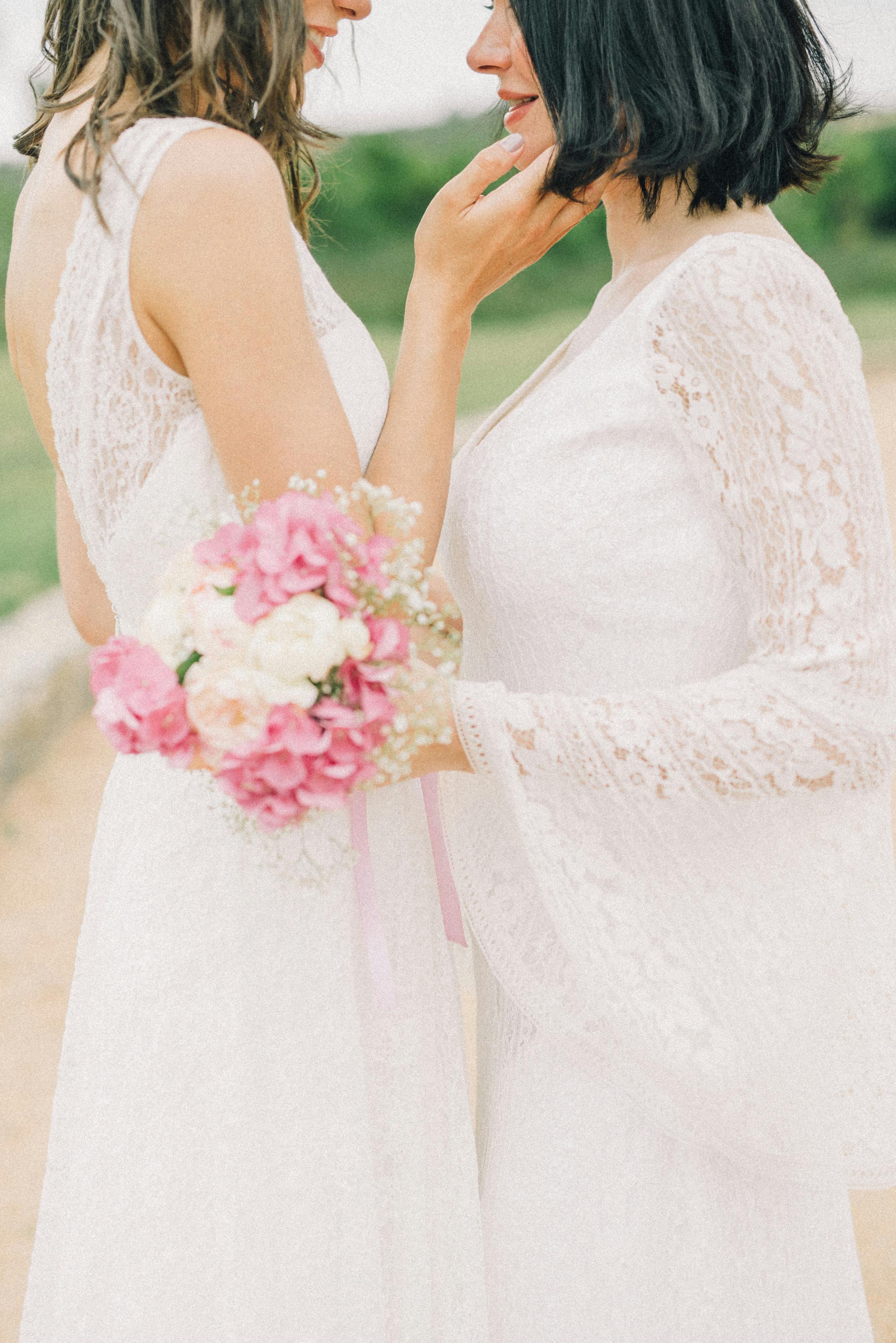 photo of women in white wedding dress looking at each other