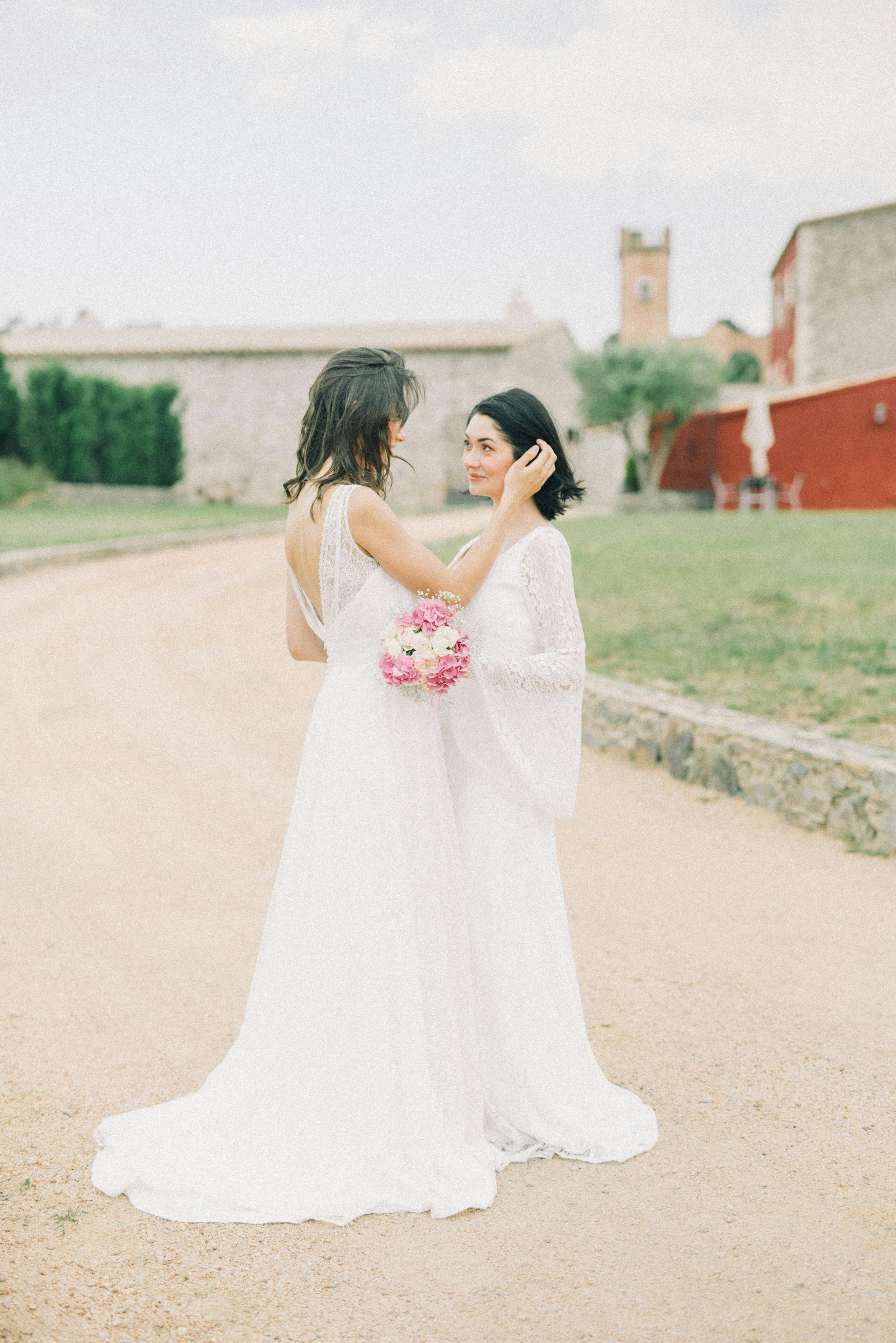 photo of women in white wedding dress looking at each other