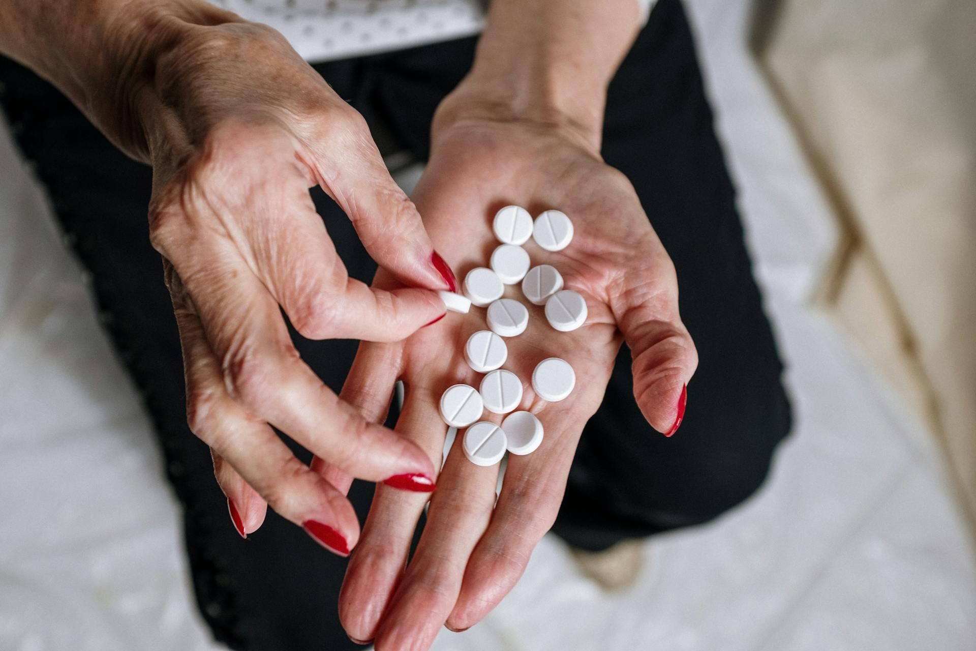 Personne tenant une pilule médicamenteuse ronde blanche