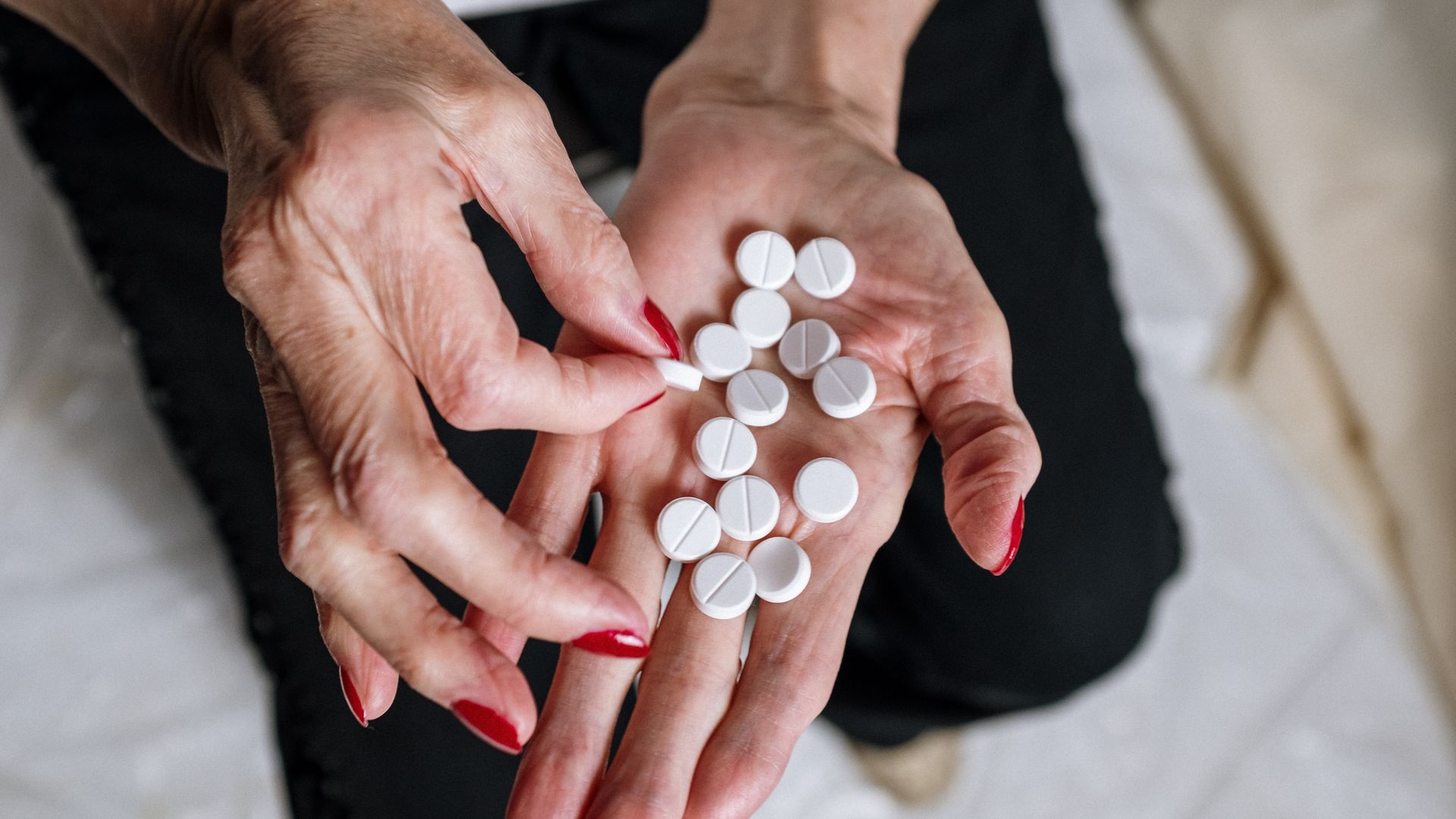 Armodafinil Side Effects: What You Need to Know Senior woman's hands with red nails holding circular white tablets, depicting medication concept — armodafinil side effects