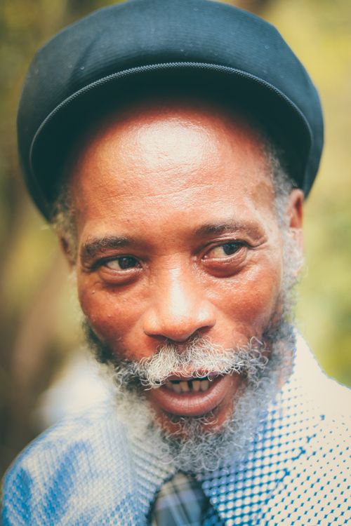 Free Portrait of a man with a beard and black cap, outdoors with a serious expression. Stock Photo