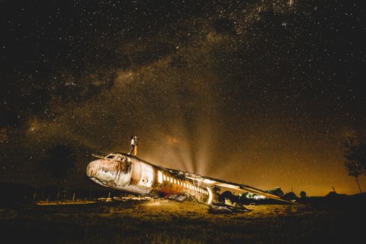 星空下，一对夫妇乘坐一架废弃飞机的场景令人着迷