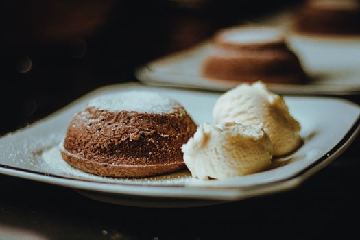 Indulge in a rich brownie served with scoops of creamy vanilla ice cream on a stylish plate.