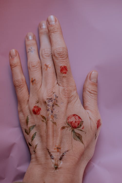 Photo of Flower Tattoos on Person's Left Hand · Free Stock Photo