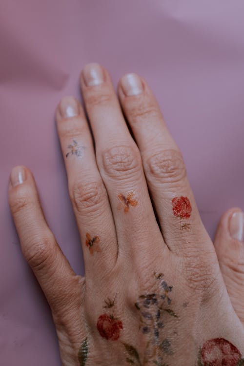 Photo of Flower Tattoos on Person's Left Hand