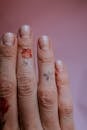 Close-Up Photo of Person's Fingers Against Pink Background
