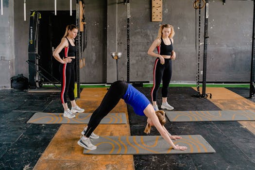 Three women engaged in yoga poses on mats in a gym environment, enhancing fitness and wellness.