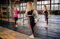 三名女性在室内进行常规健身，主要侧重于伸展和健康