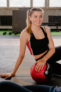 一位健康快乐的女士身着健身服，手持健身球，散发着健康的气息