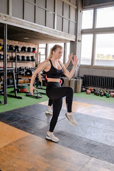 Woman performing a high-intensity workout in a well-equipped gym environment.