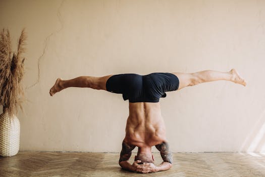 A man performs a yoga headstand in a serene indoor setting, showcasing balance and flexibility.