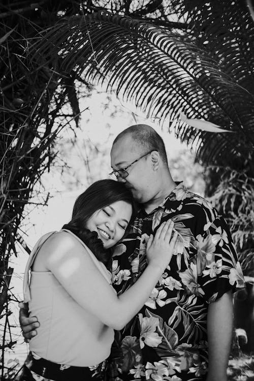 Grayscale Photo of Man Kissing His Woman