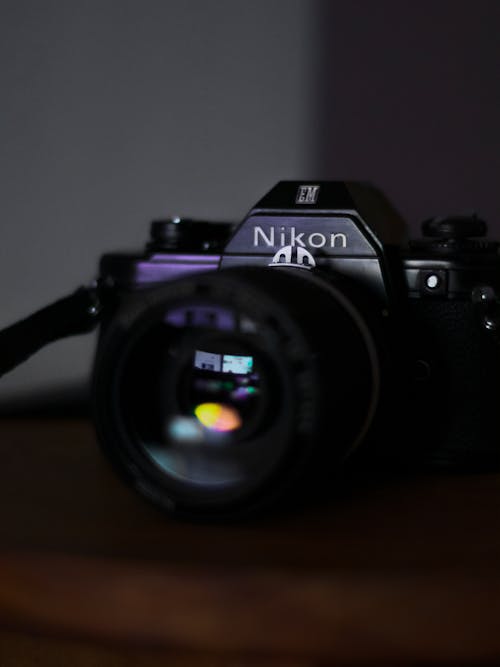 Black Nikon Dslr Camera on Brown Wooden Table